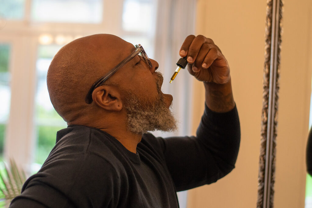 Man with CBD oil dropper .
